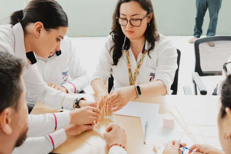 Colaboradoras construyendo una estructura en equipo durante la dinámica