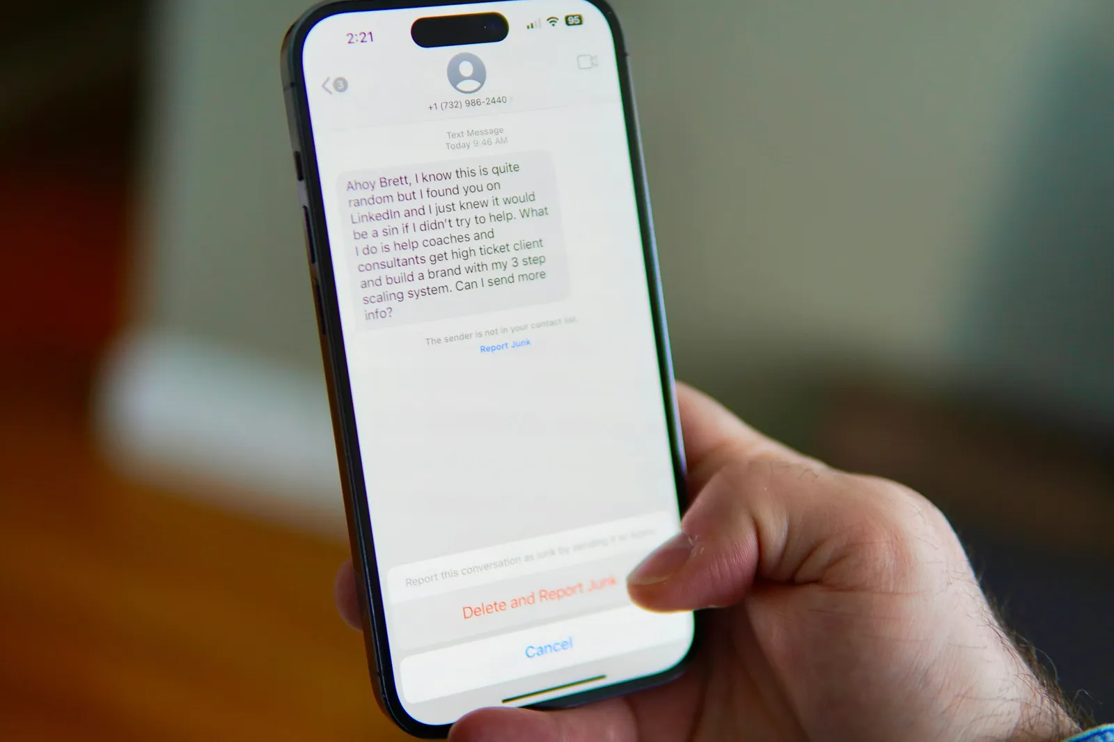 Mano sosteniendo un celular con un mensaje de texto en pantalla